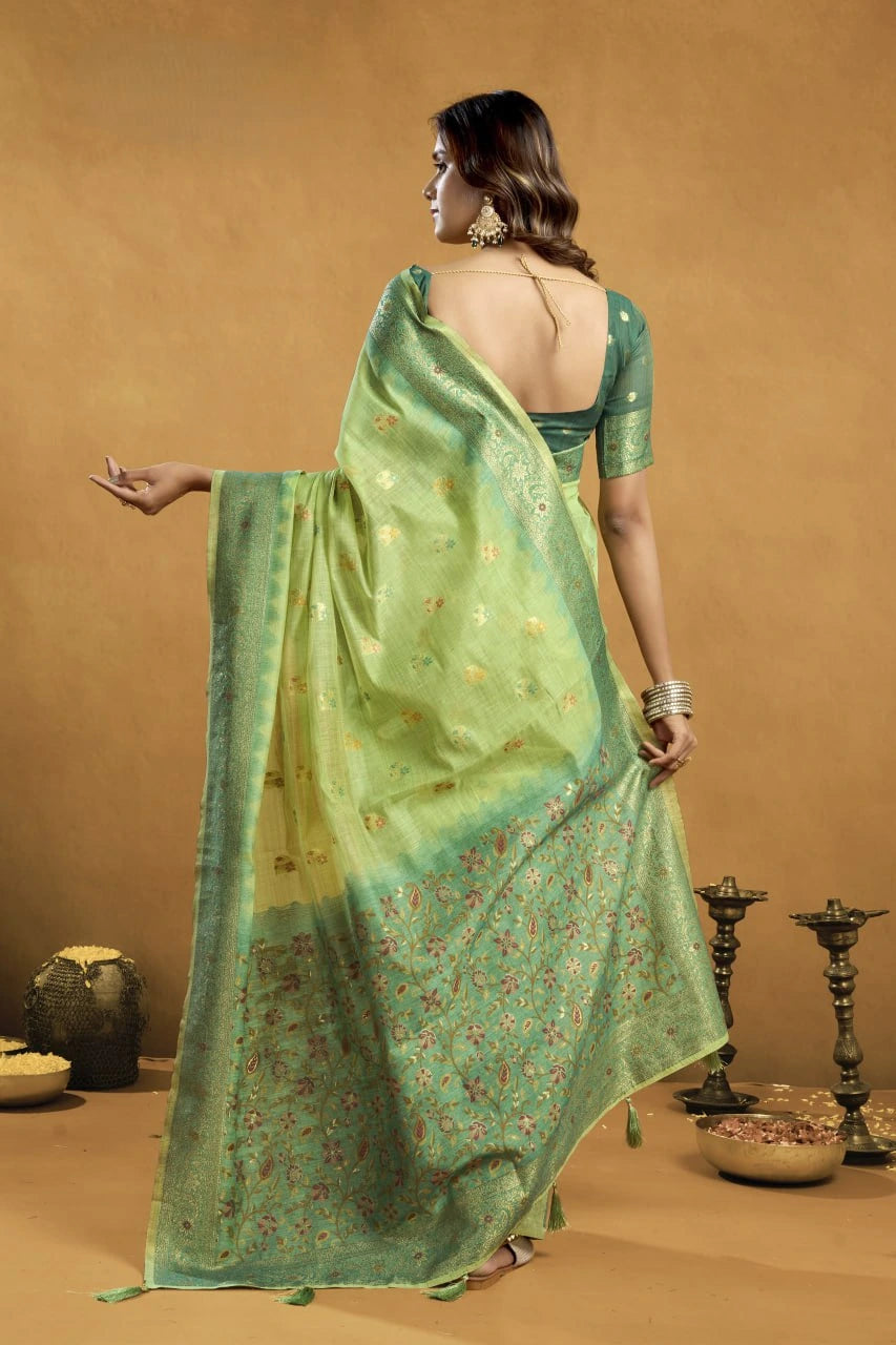 Woman wearing a green saree with a floral pattern against a brown background